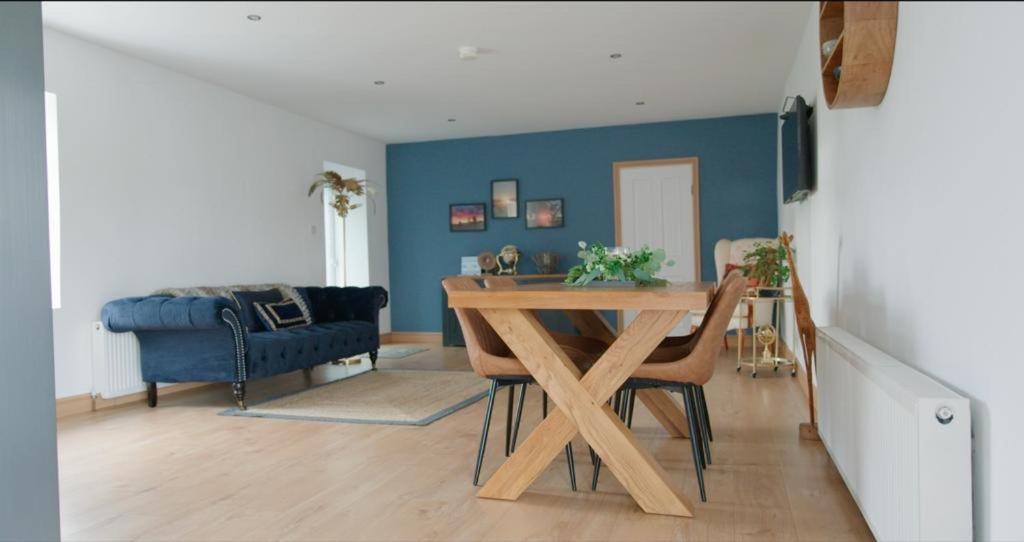 ein Wohnzimmer mit einem Tisch und einer blauen Wand in der Unterkunft Unique countryside stay in Dundrod