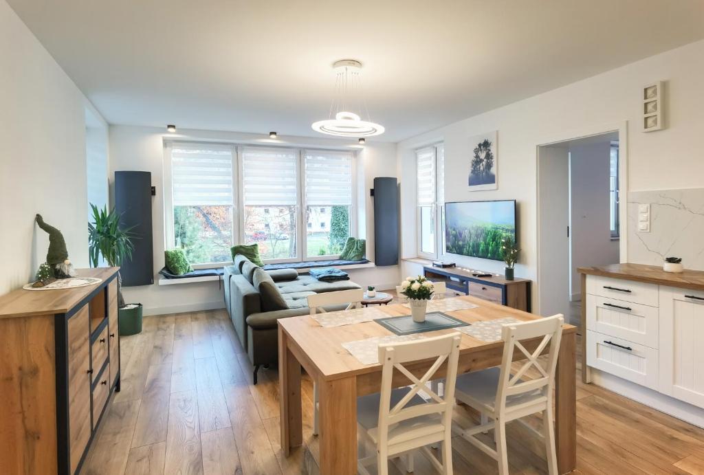 kuchnia i salon ze stołem i kanapą w obiekcie Apartament Green Forest w mieście Duszniki Zdrój