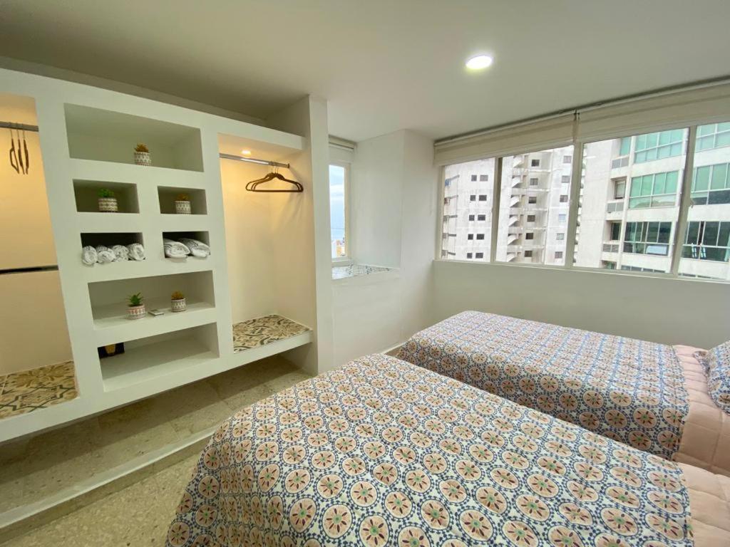 ein Schlafzimmer mit zwei Betten und einem Fenster in der Unterkunft Apartamento frente al mar en Cartagena in Cartagena de Indias