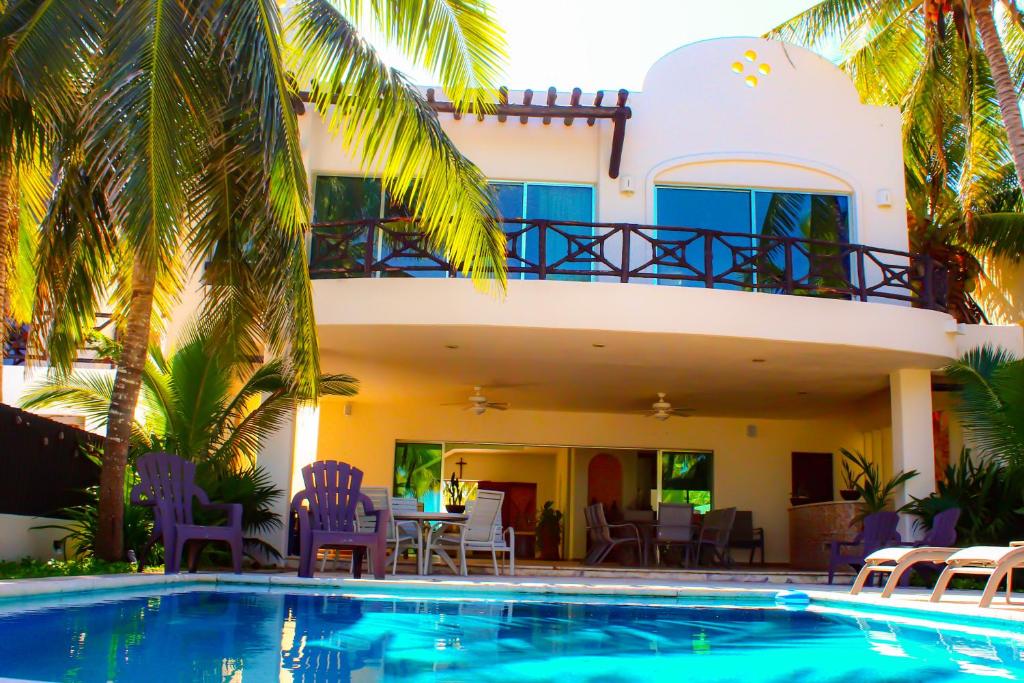 a villa with a swimming pool in front of a house at Paros a gulf of Mexico paradise in Uaymitun