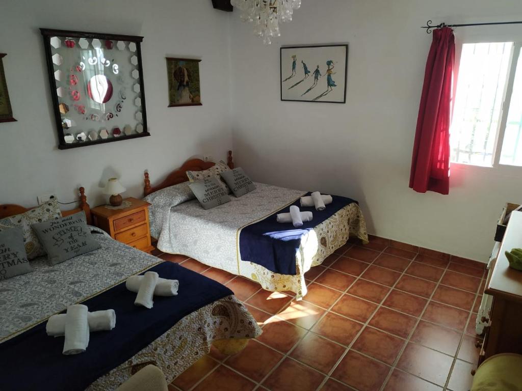 a bedroom with two beds and a tiled floor at Loma Negra in Dúrcal