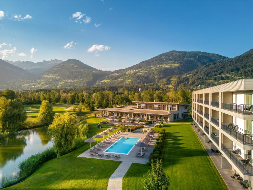 an aerial view of a resort with a pool and mountains at Dolomitengolf Suites in Lavant