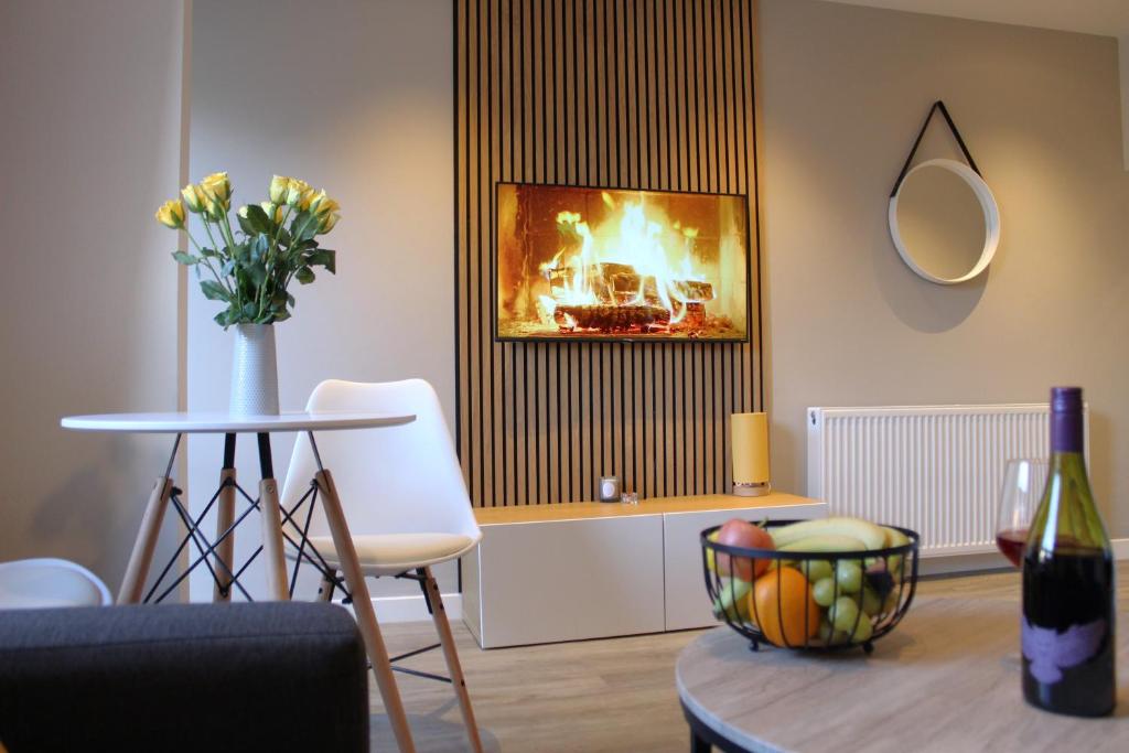 - un salon avec une table et une cheminée dans l'établissement Modern Craigie Apartment, à Perth