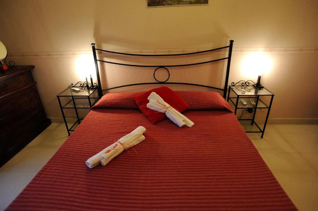 ローマにあるLa Casa Romanaの大型赤いベッド(白い枕2つ付)