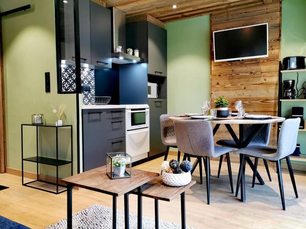 une cuisine et une salle à manger avec une table et des chaises dans l'établissement Studio rénové avec kitchenette, balcon et wifi - FR-1-598-84, aux Gets