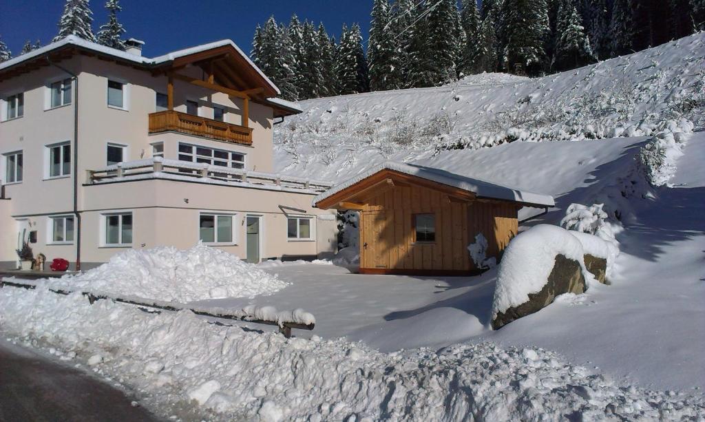 ein schneebedecktes Haus vor der Tür in der Unterkunft Apartment Valentina in Neustift im Stubaital