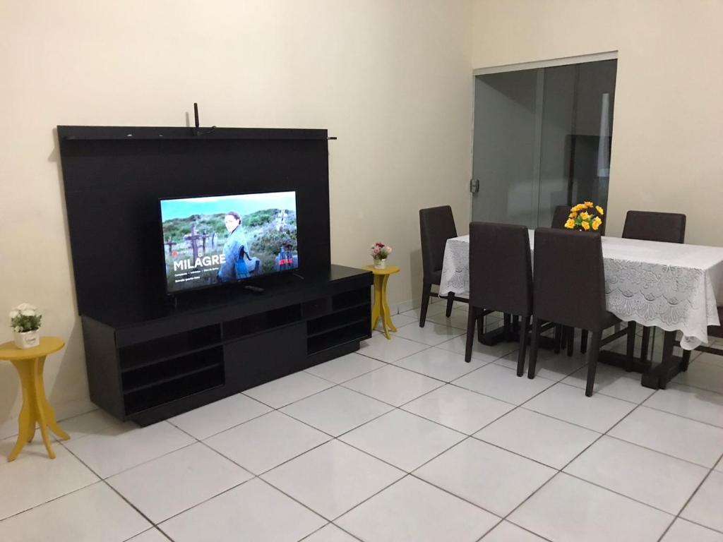 uma sala de estar com uma televisão e uma mesa de jantar em Casa Park Massangano em Petrolina