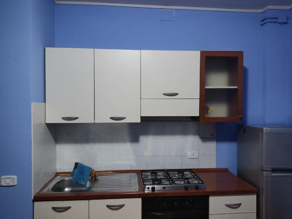 La cuisine est équipée de placards blancs et d'un four avec plaques de cuisson. dans l'établissement Affittacamera Mauro vasto, à Vasto