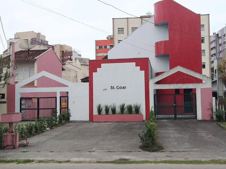 a white and red building with a sign on it at Triplex em Caiobá-Matinhos-Pr a 200 mt do mar in Matinhos