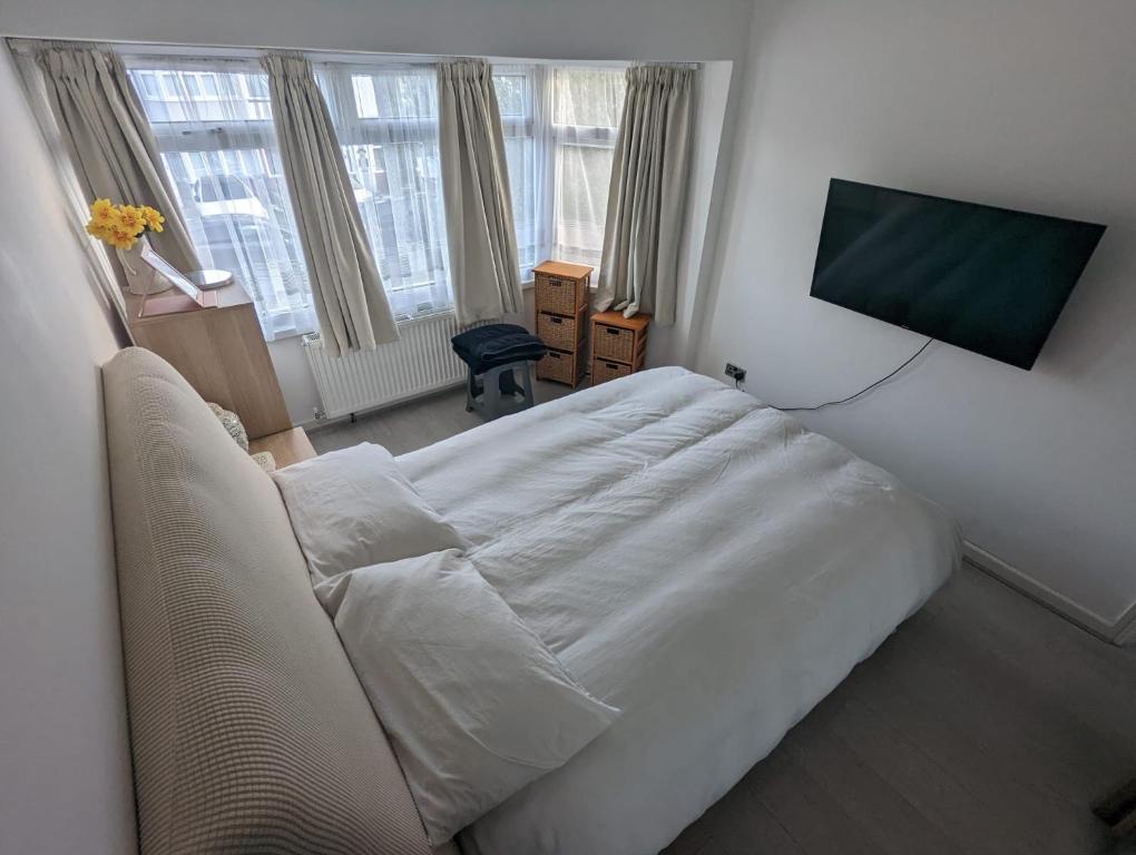 エドモントンにあるSpacious 2 bedroom house with gardenのベッドルーム(白いベッド1台、薄型テレビ付)