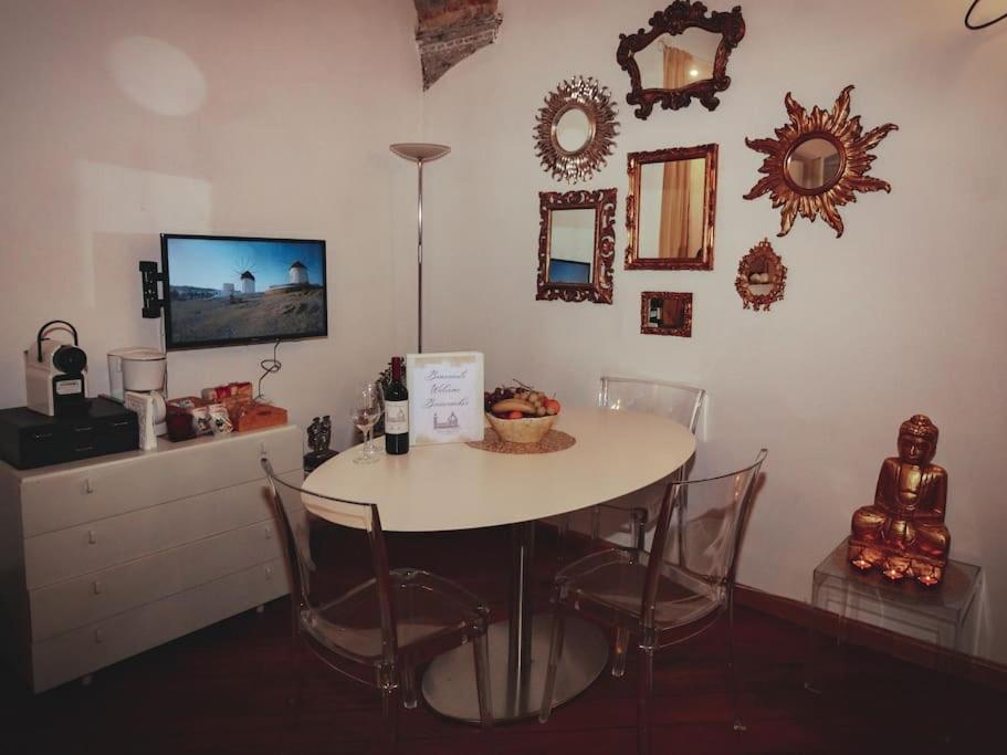 einen Esstisch mit Stühlen und Spiegeln an der Wand in der Unterkunft Nest in Florence in Florenz