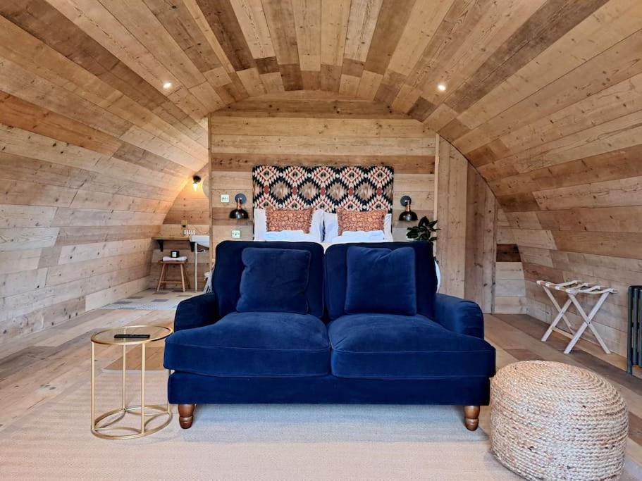 ein blaues Sofa in einem Zimmer mit Holzdecke in der Unterkunft The Pigsty in Crieff