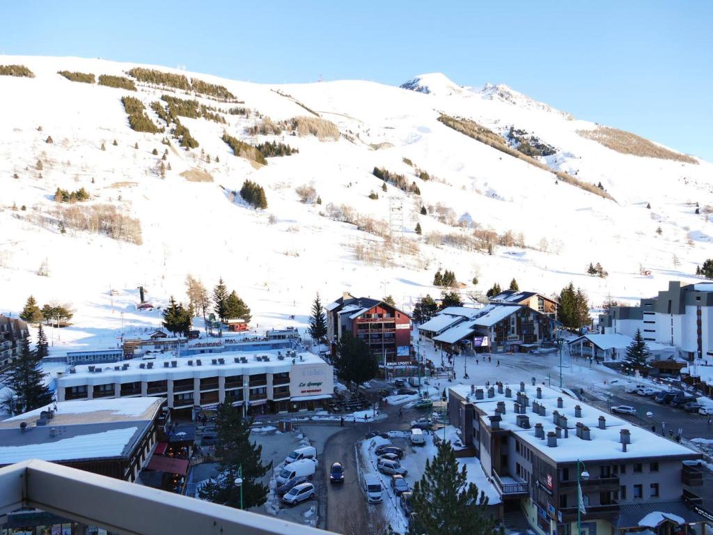 une ville avec une montagne enneigée en arrière-plan dans l'établissement Joli studio centre station avec lits superposés - FR-1-546-45, à Les Deux Alpes