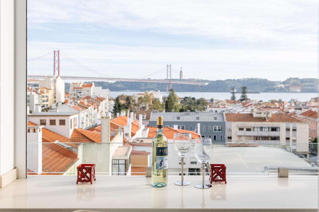 a bottle of wine and glasses on a table with a view at Tejo River View Apartment nearby Belém in Lisbon