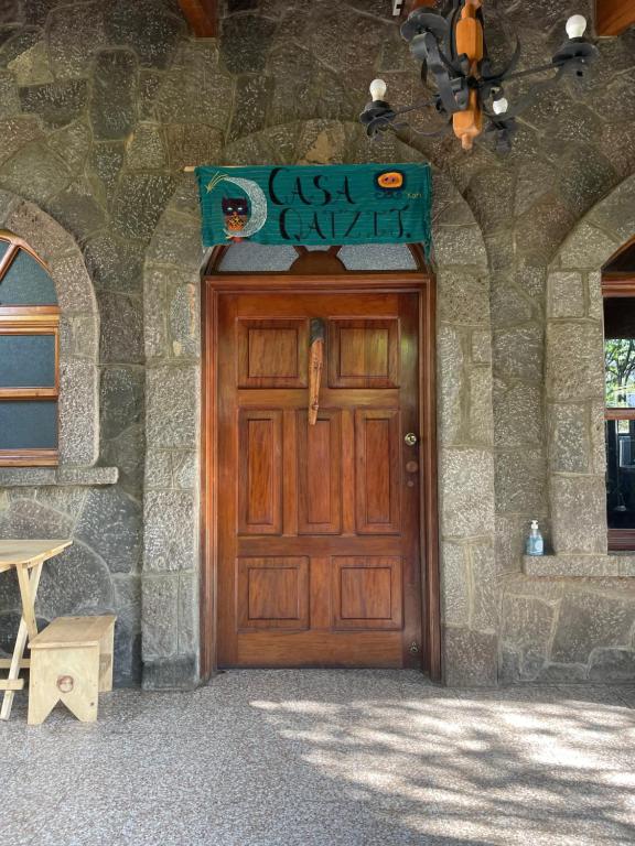 eine Holztür eines Steingebäudes mit einem Schild darüber in der Unterkunft Casa Qatzij - Guest House, Lake Atitlan in San Lucas Tolimán