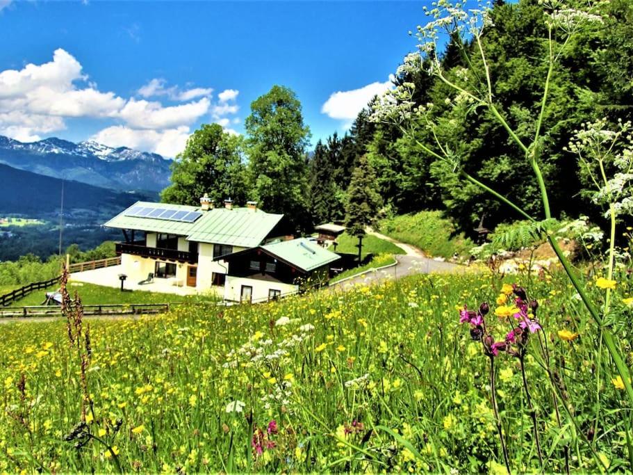 uma casa numa colina com um campo de flores em 5 Bergpanorama und herrliche alpinen Almlandschaft Nichtraucherdomizil em Schönau am Königssee