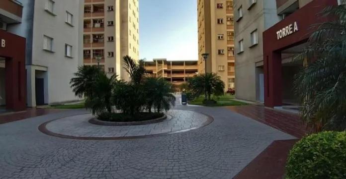 un patio en un edificio con palmeras y edificios en Departamento 2 Ambientes en Edificio Céntrico en Resistencia