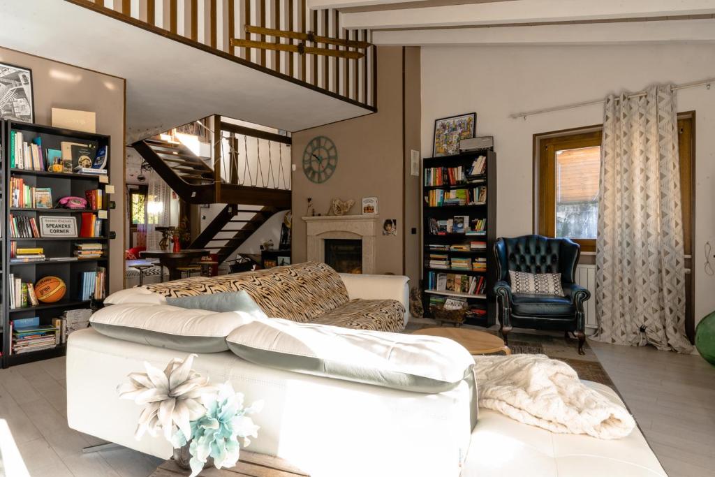 uma sala de estar com um sofá branco e uma escada em Casa Furia em Ponte della Venturina