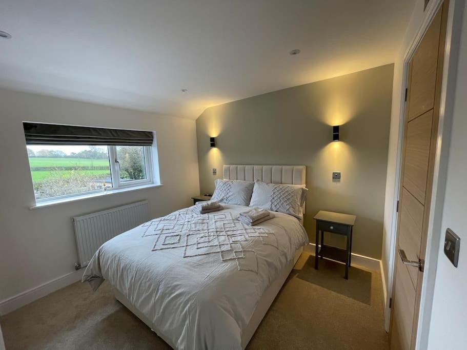 a bedroom with a large white bed with a window at Newly renovated 3 Bed property - countryside views in Dunstall