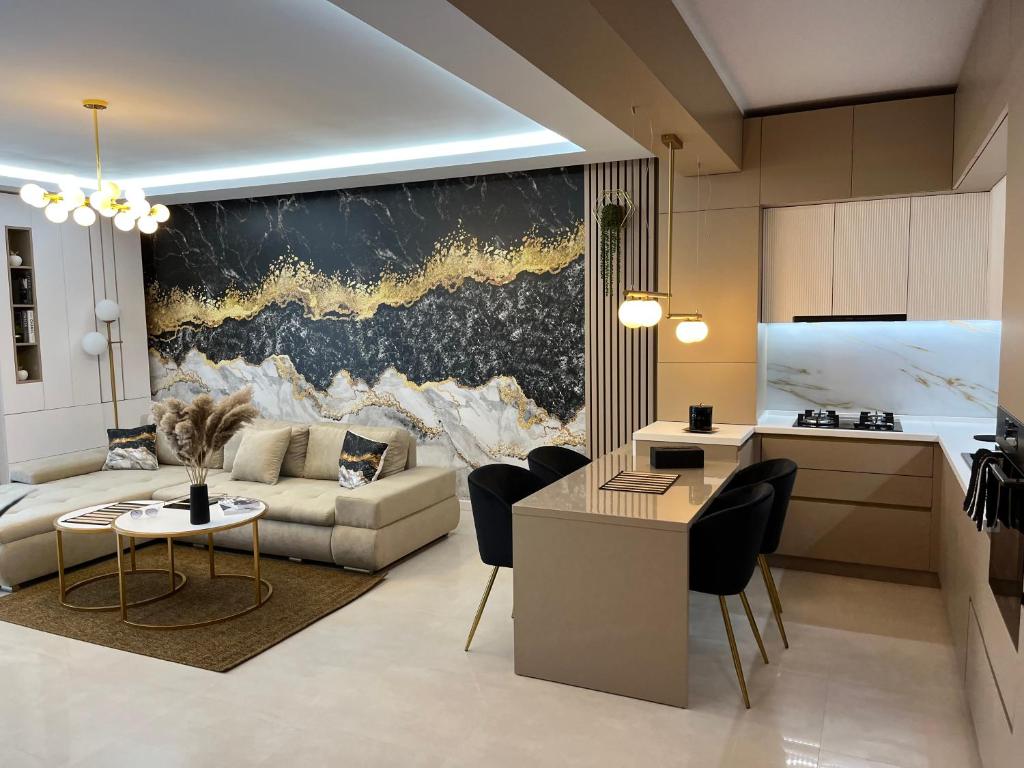SAS 2 Luxury Apartments في مامايا: مطبخ وغرفة معيشة مع أريكة وطاولة