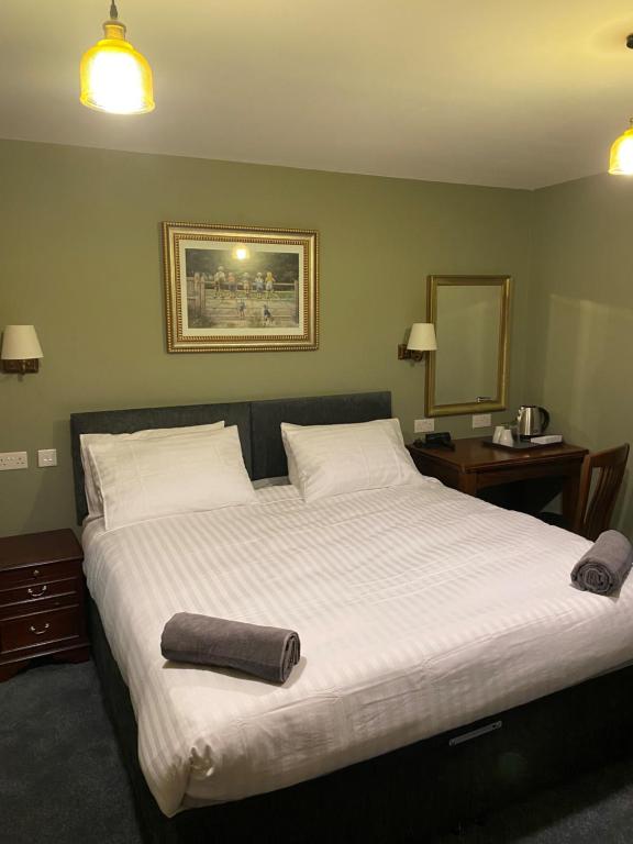 a bedroom with a large bed with white sheets and a mirror at Unicorn in Selby