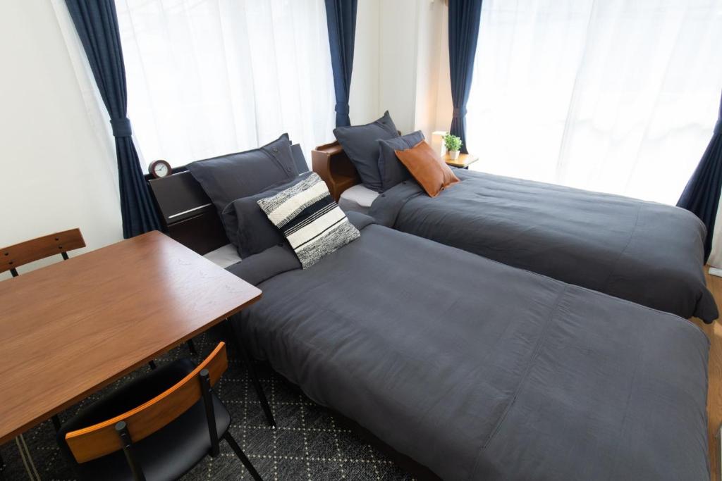 a room with two beds and a table and a desk at Amber Iidabashi - Vacation STAY 90475v in Tokyo