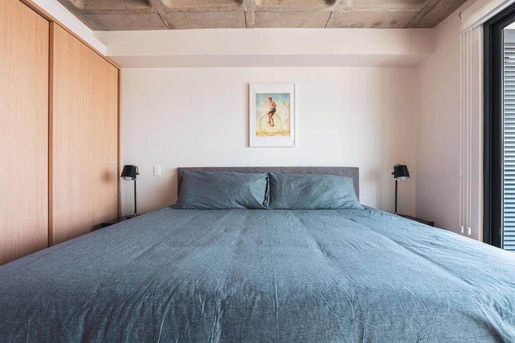 una camera da letto con un grande letto e un piumone blu di Etre 1408 a Città del Messico