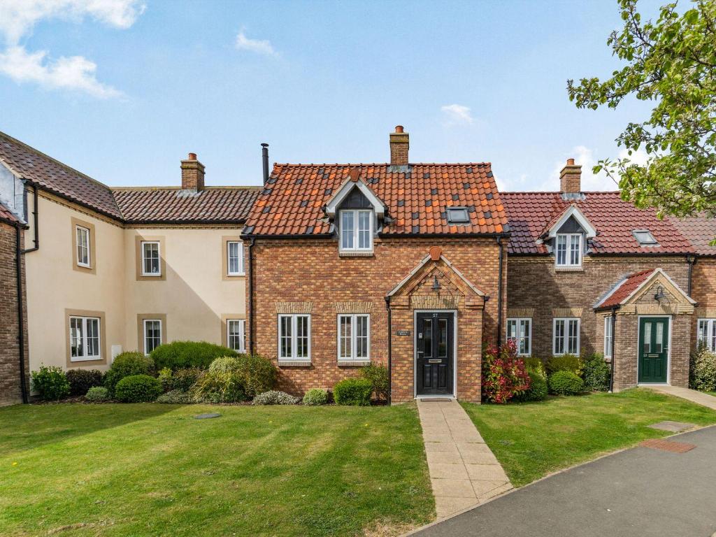 a large brick house with a green lawn at Lantern House in Filey