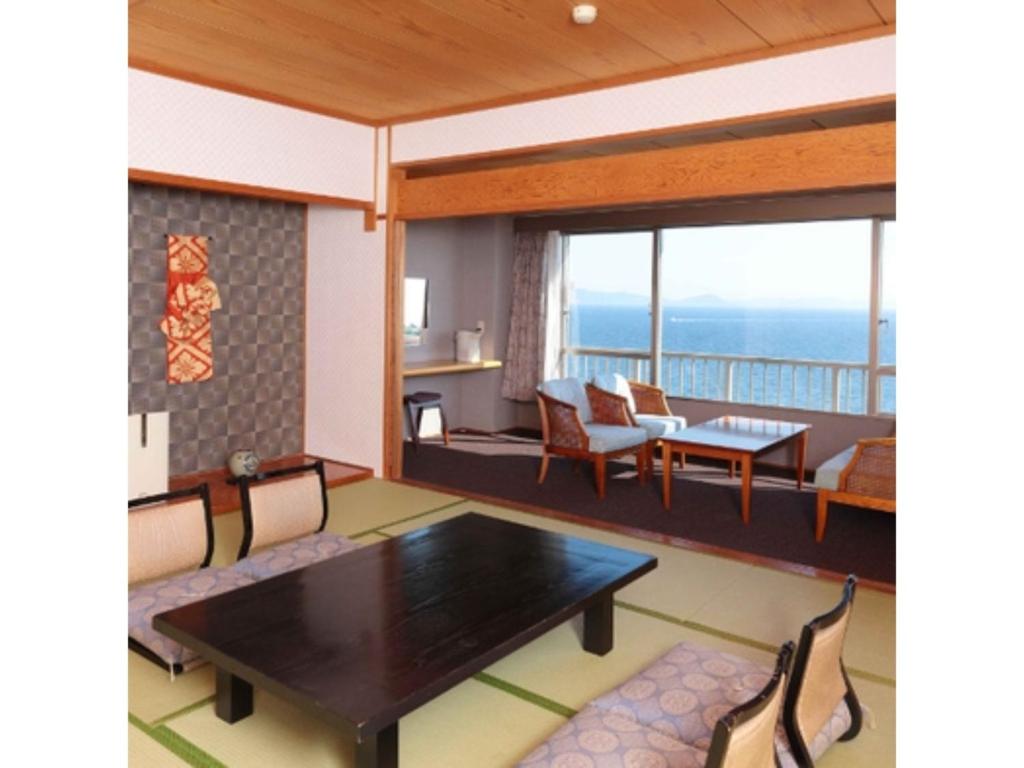 Hotel Mikawa Kaiyoukaku - Vacation STAY 90625v في غاماغوري: غرفة معيشة مع طاولة وكراسي