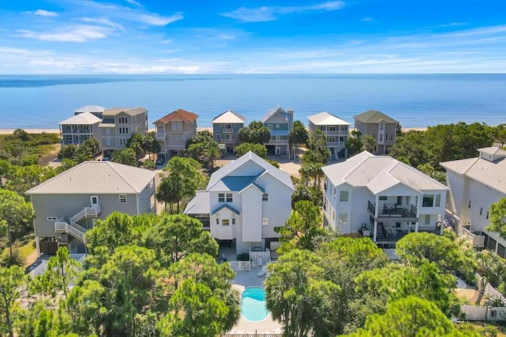 an aerial view of a row of houses with the ocean in the background at Casablanca - Beach home with heated pool, bikes and more, sleeps 13! in St. George Island