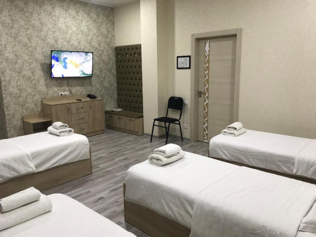 a hospital room with two beds and a television at MAZZA Hotel in Tashkent