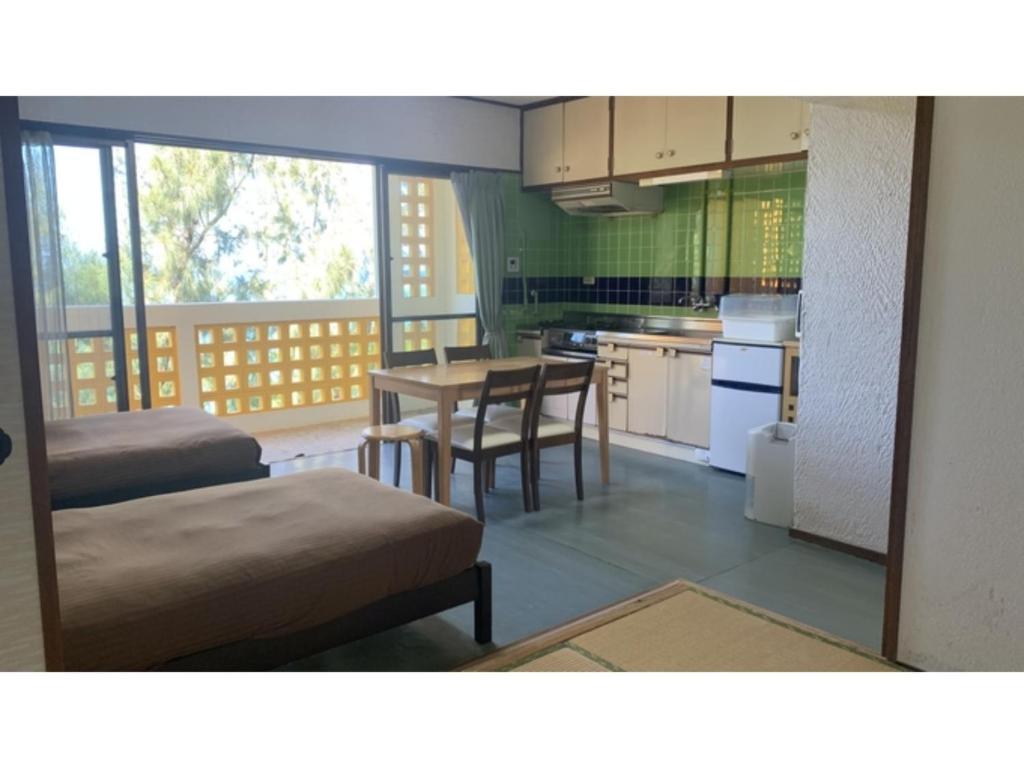 eine Küche und ein Esszimmer mit Tisch und Stühlen in der Unterkunft On the Beach Lue - Vacation STAY 91567v in Sesoko