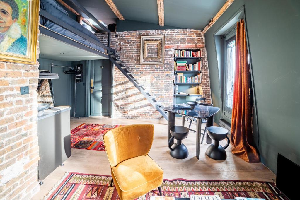 a room with a brick wall and a table and chairs at Place Vendôme Luxe 60 SQM Bail mobilité in Paris