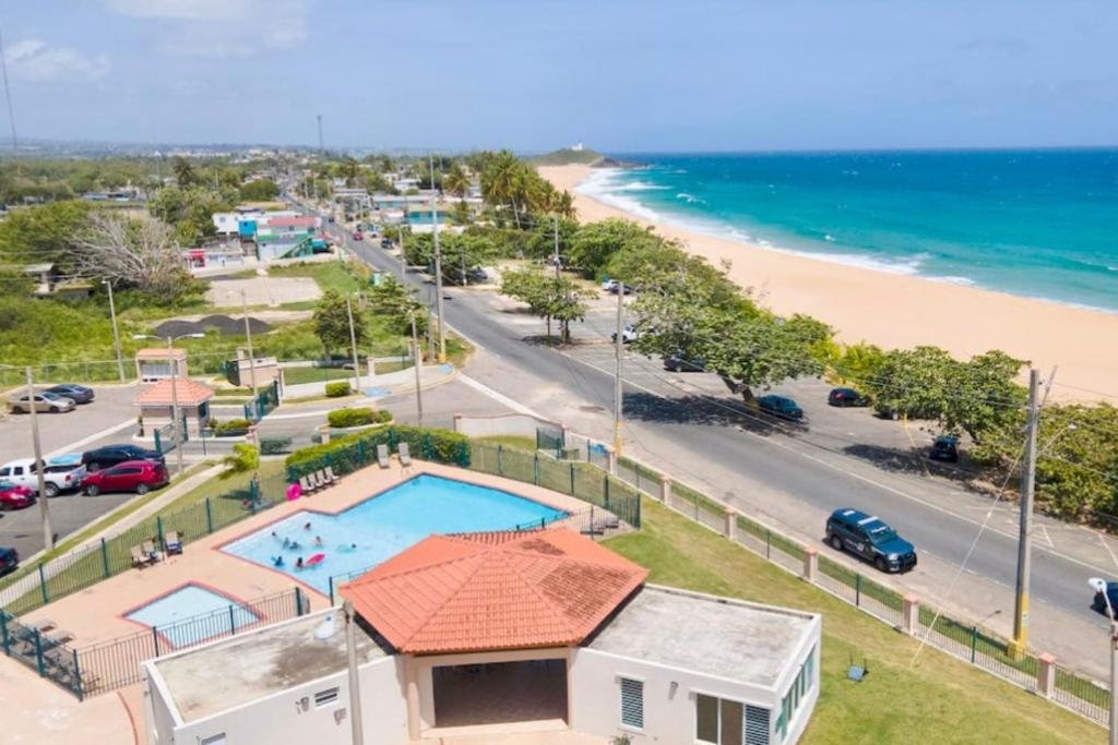 a house with a swimming pool next to a beach at Apartamento frente a la Playa Arecibo Puerto Rico in Arecibo