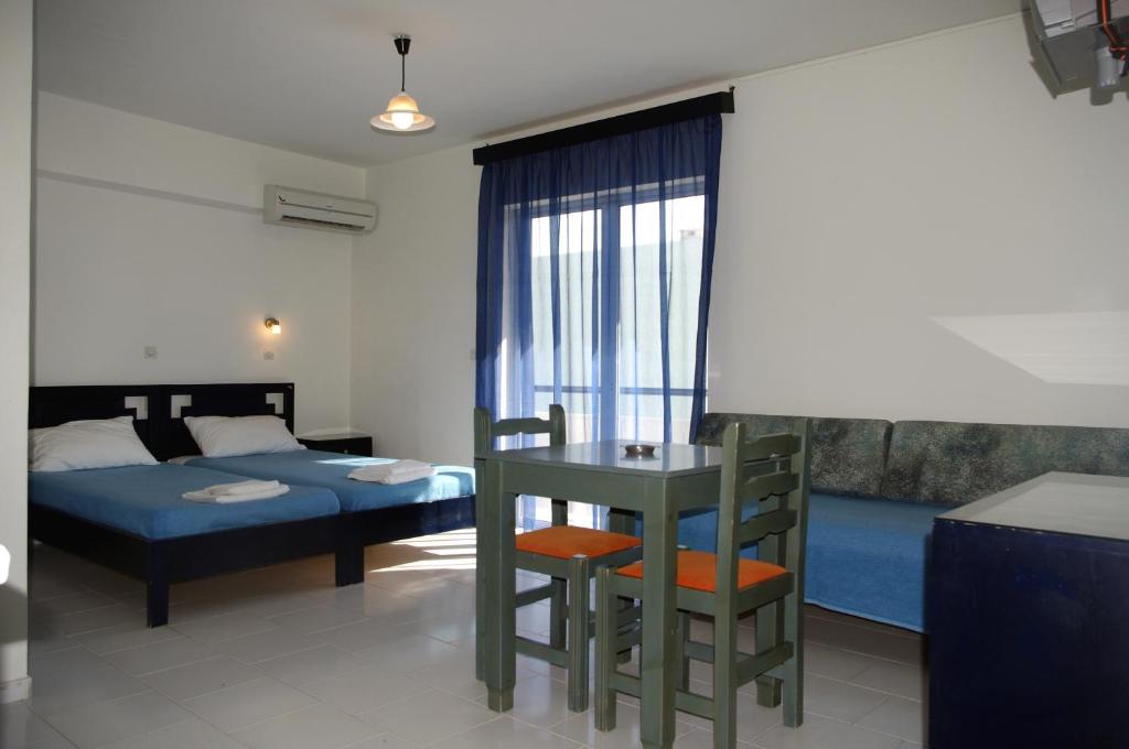 a bedroom with a bed and a table and chairs at Klery Studios in Hersonissos