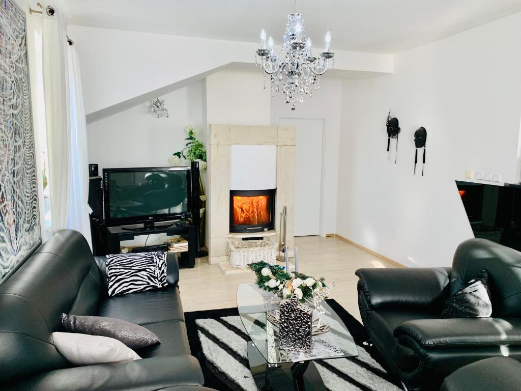 a living room with black leather furniture and a fireplace at Apartmán Residenz in Poprad