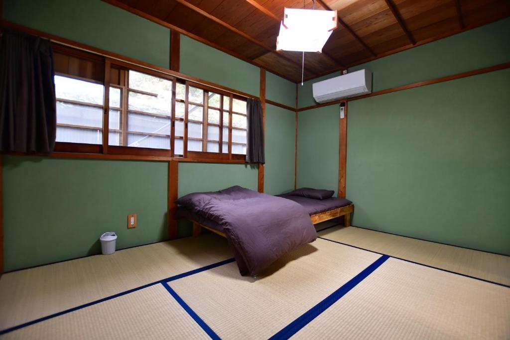 a bedroom with green walls and a bed in it at boschetto - Vacation STAY 05407v in Kami-ichi