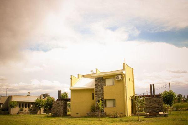 una casa amarilla en medio de un campo en Cabañas Alto Chañaral en San Rafael