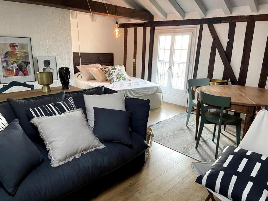 a living room with a couch and a bed and a table at Appartement dans le Vieux Mans in Le Mans