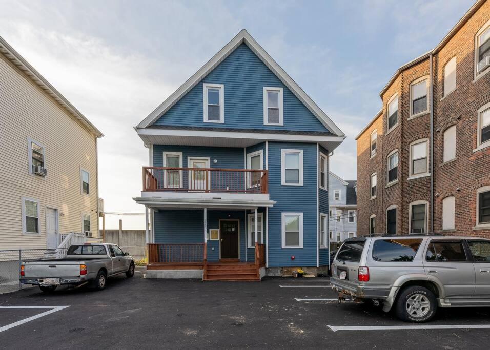 een blauw huis met een balkon op een parkeerplaats bij 233/1-Boston family-friendly first floor apartment in Boston
