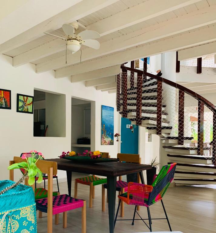 圣安德烈斯Casa de las Flores tropical的一间有桌椅和楼梯的餐厅