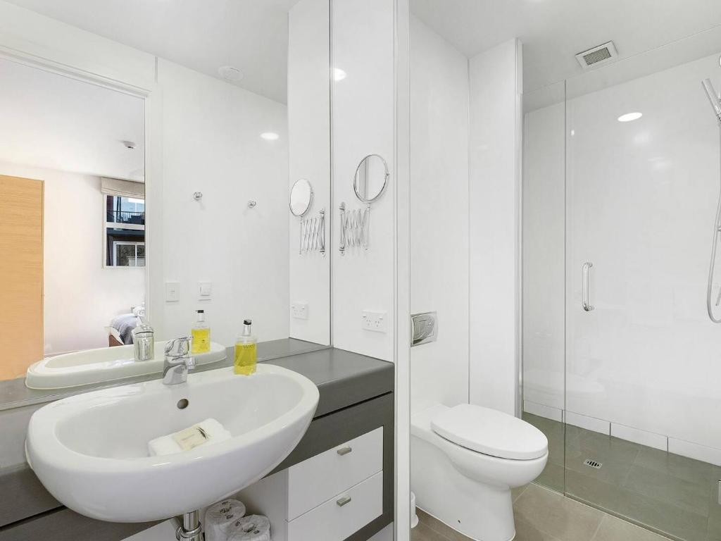 Baño blanco con lavabo y aseo en Marina Gem - Lakefront 3 Bedroom Apartment, en Queenstown