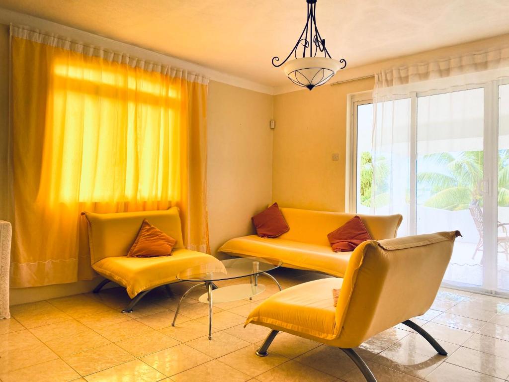 a living room with two yellow chairs and a window at El Paraiso in La Gaulette