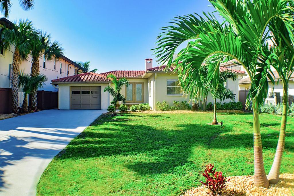 a house with palm trees in front of a driveway at Devon Shores in Clearwater Beach