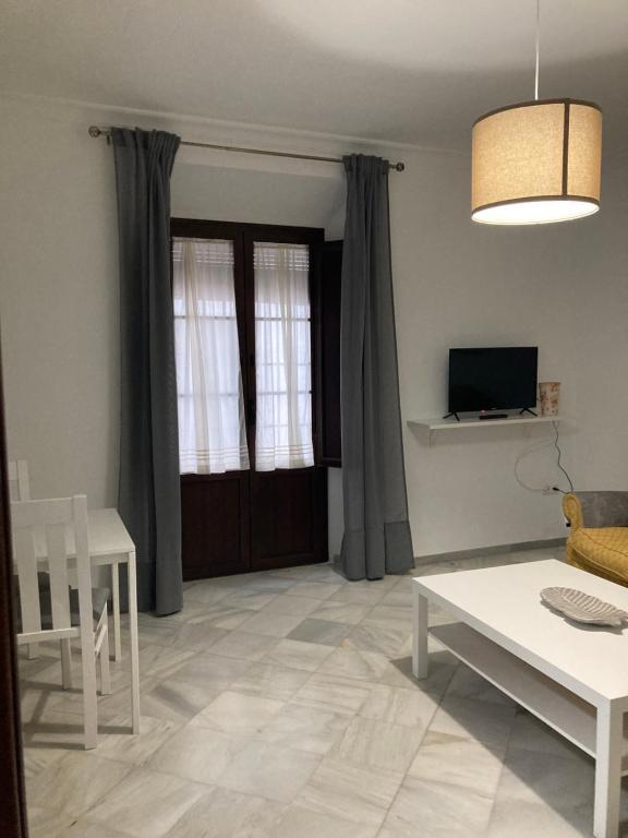 uma sala de estar com um sofá e uma mesa em Duplex Santamaria em Carmona