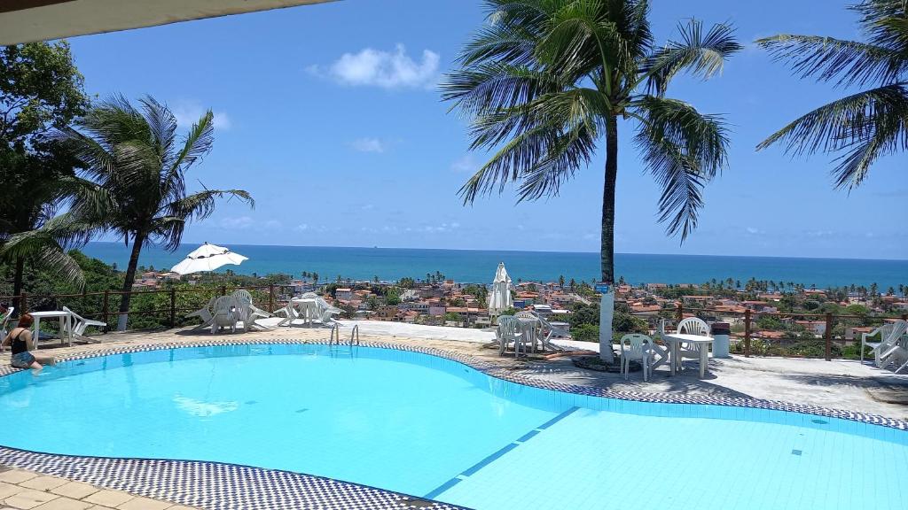 a large swimming pool with a view of the ocean at Rest e Pousada LookBeach in Cabo de Santo Agostinho