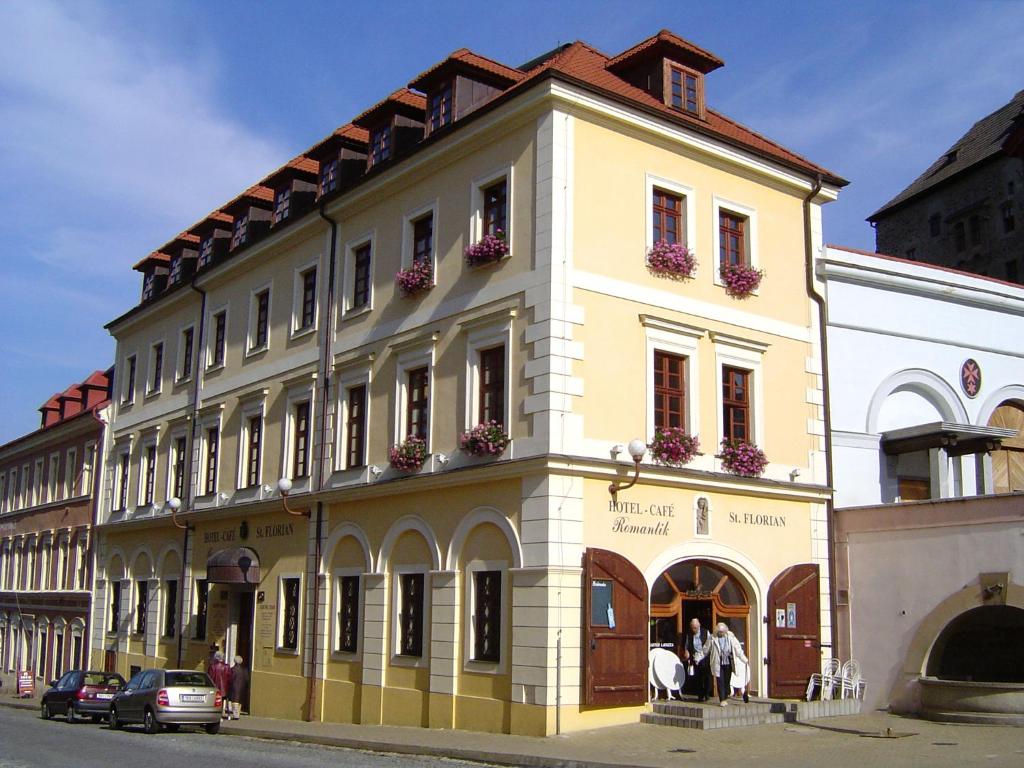 a large yellow building with people in the window at Hotel St Florian in Loket