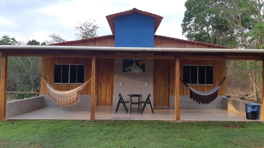 uma casa com um alpendre com redes de descanso em Chalé Estância da Mata Nobres MT em Nobres