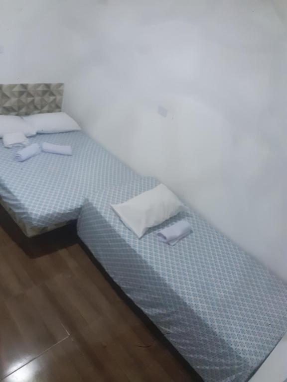 a bedroom with a bed with a blue bedspread at Hospedagem da barra suites,praia barra grande,caminho de moises e antunes in Maragogi