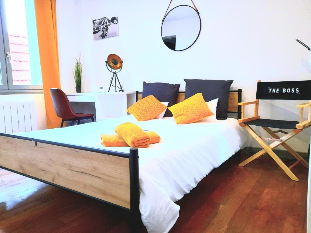 a bedroom with a bed with yellow and black pillows at L'Orée du Marais - Paisible maison centre-ville in Bourges